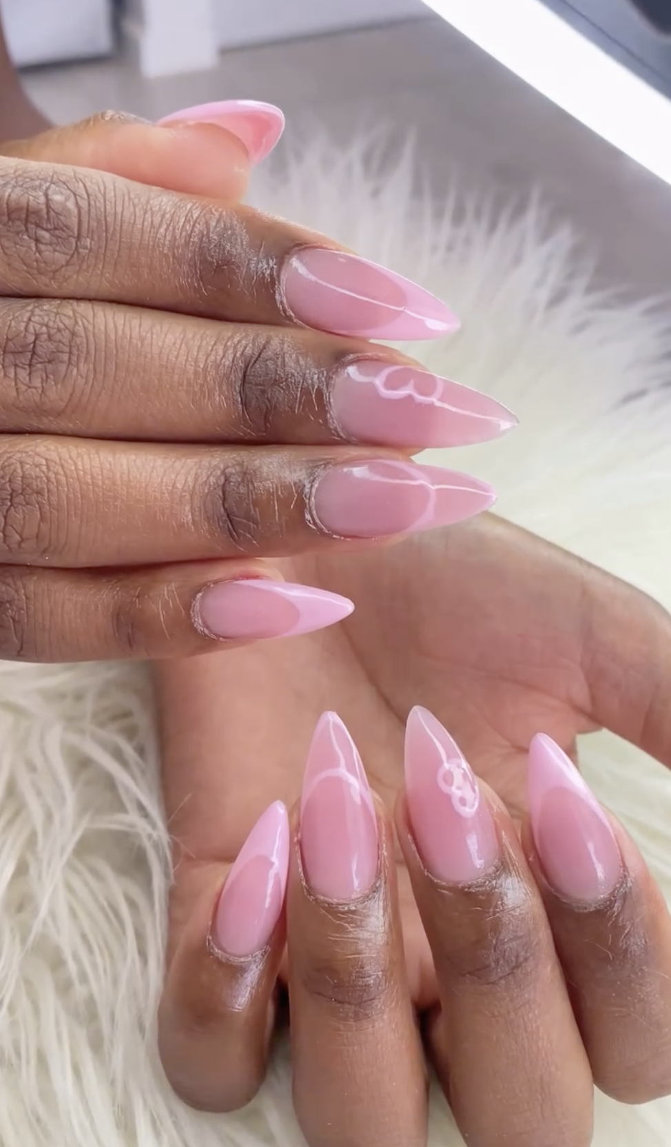 Baby pink nails with subtle heart and bow nail art