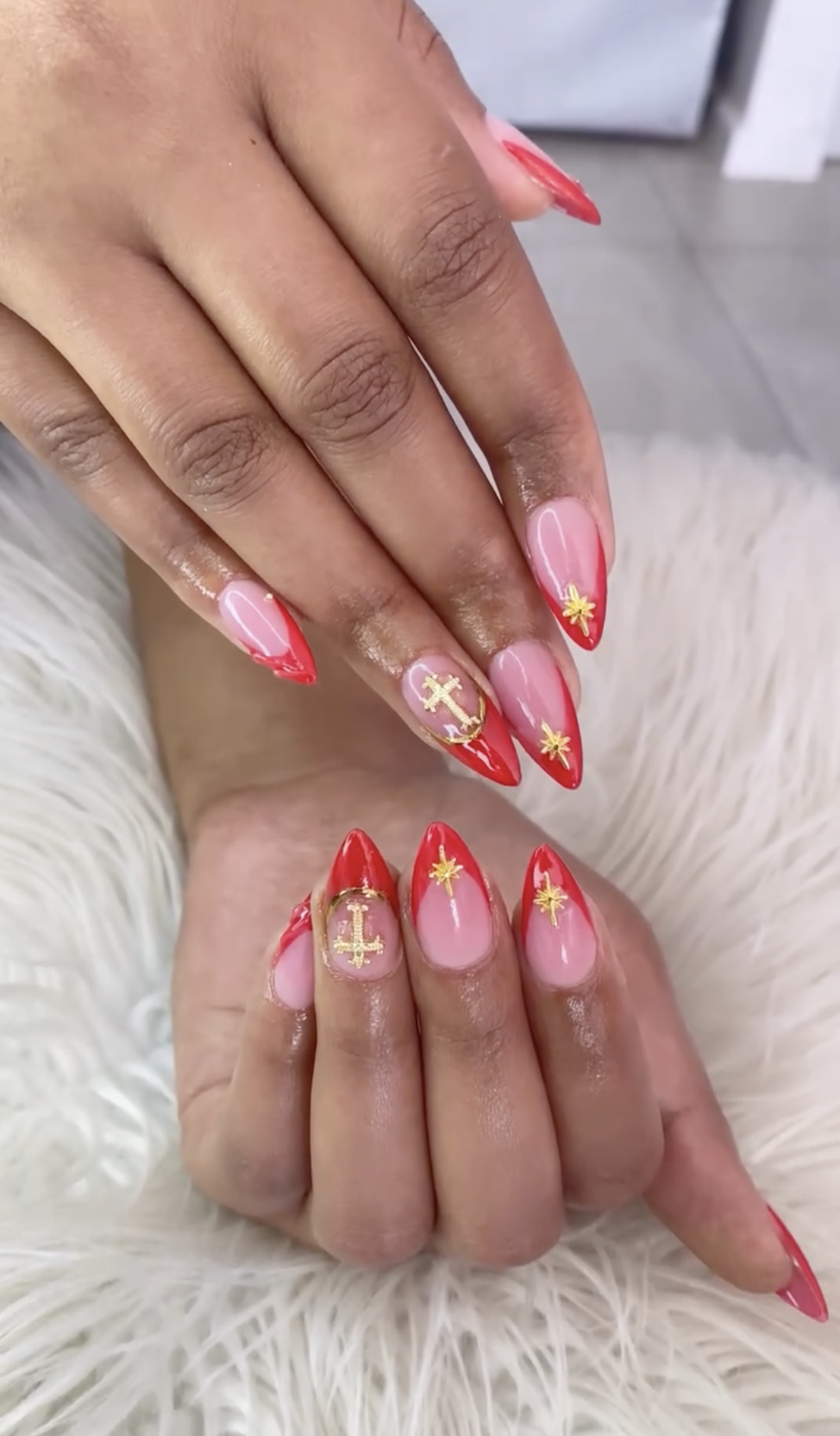 Red French tips with gold cross and star nail art