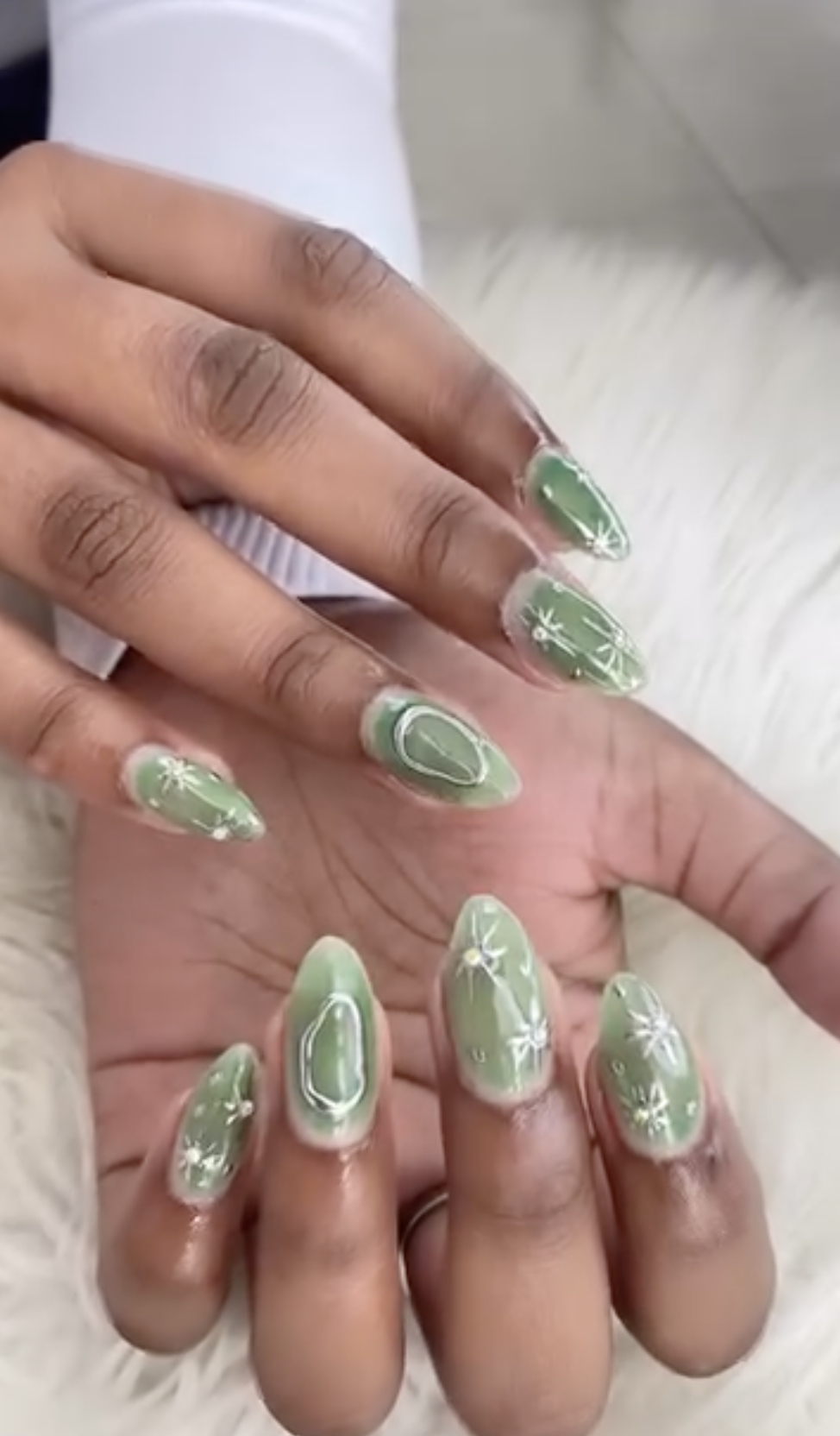 Sage green nails with white star and snowflake nail art